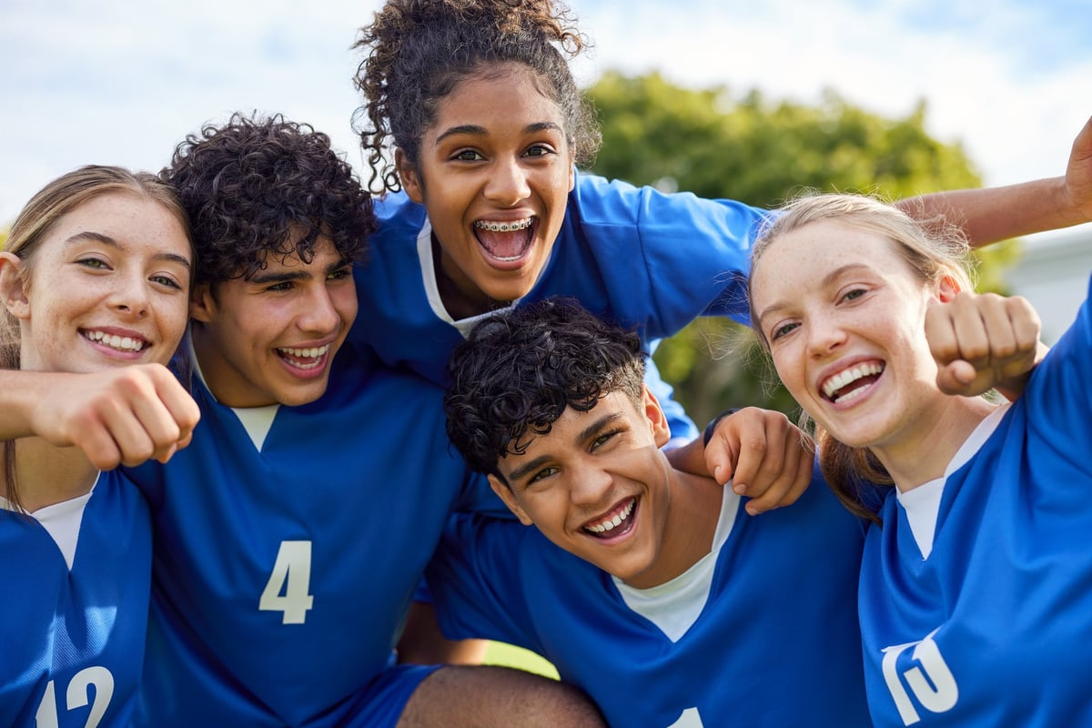 Jóvenes deportistas celebrando juntos en el campo